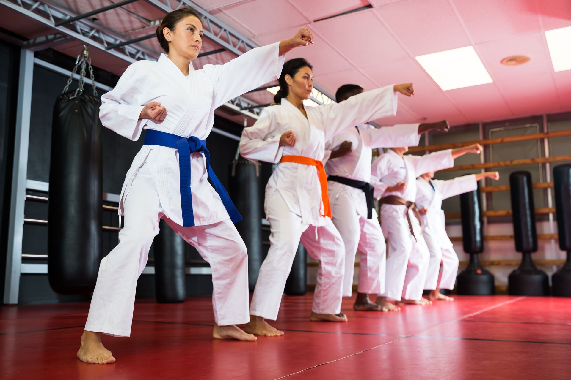 Polyethnic men and women in kimono exercising kata