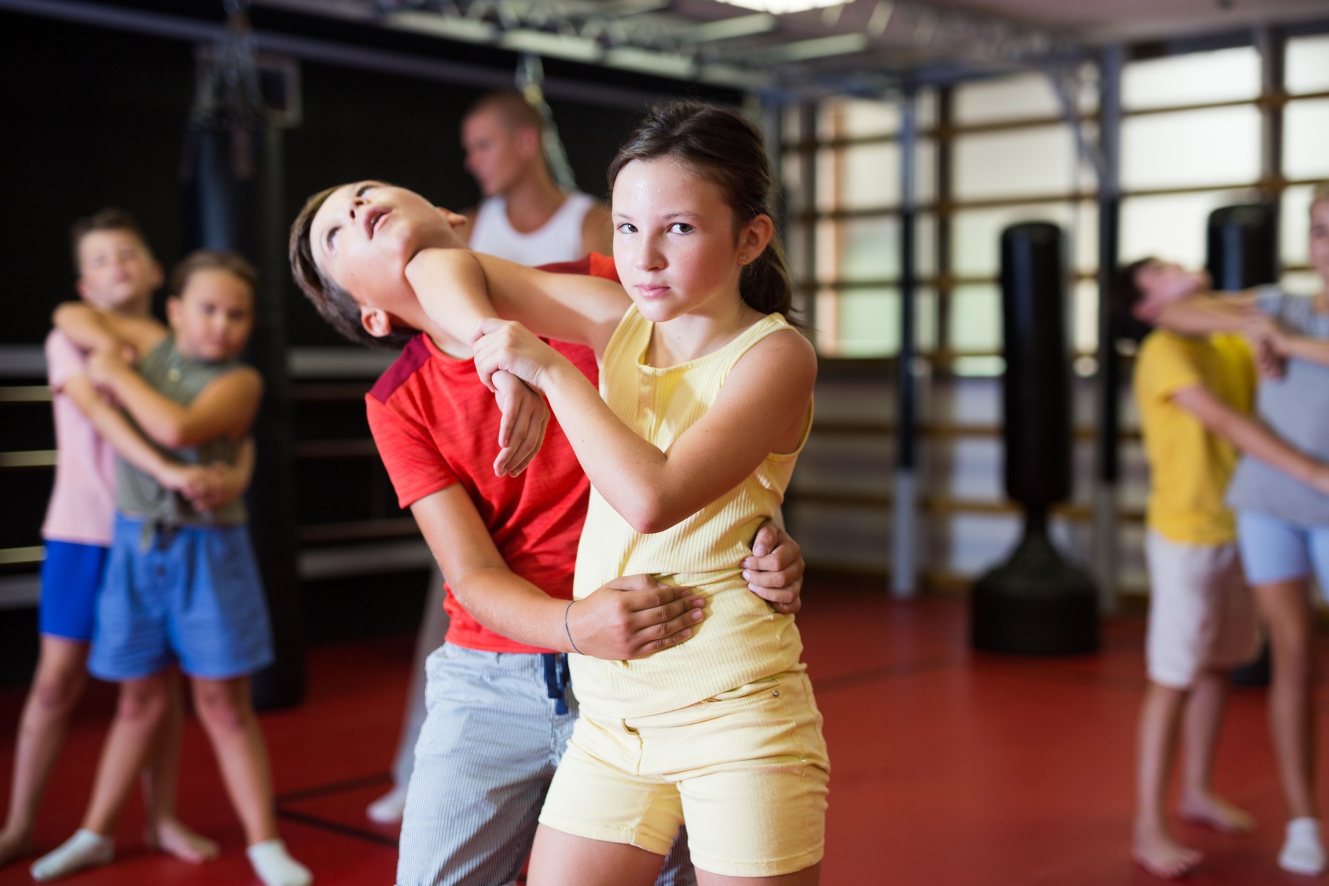 Boy and girl in pair exercising self-defense movements