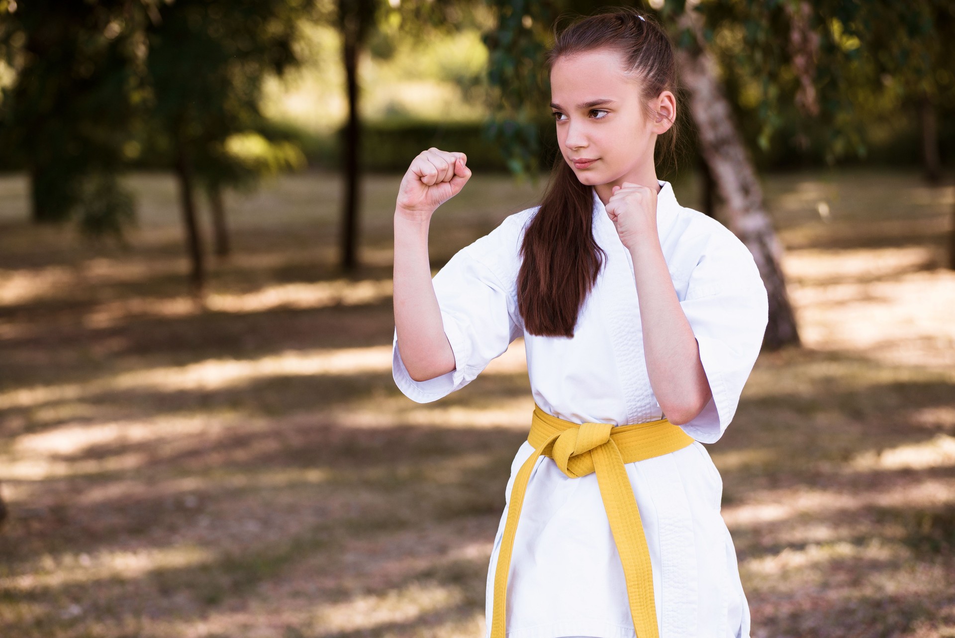 Portrait of girl doing martial arts at summer park outdoors